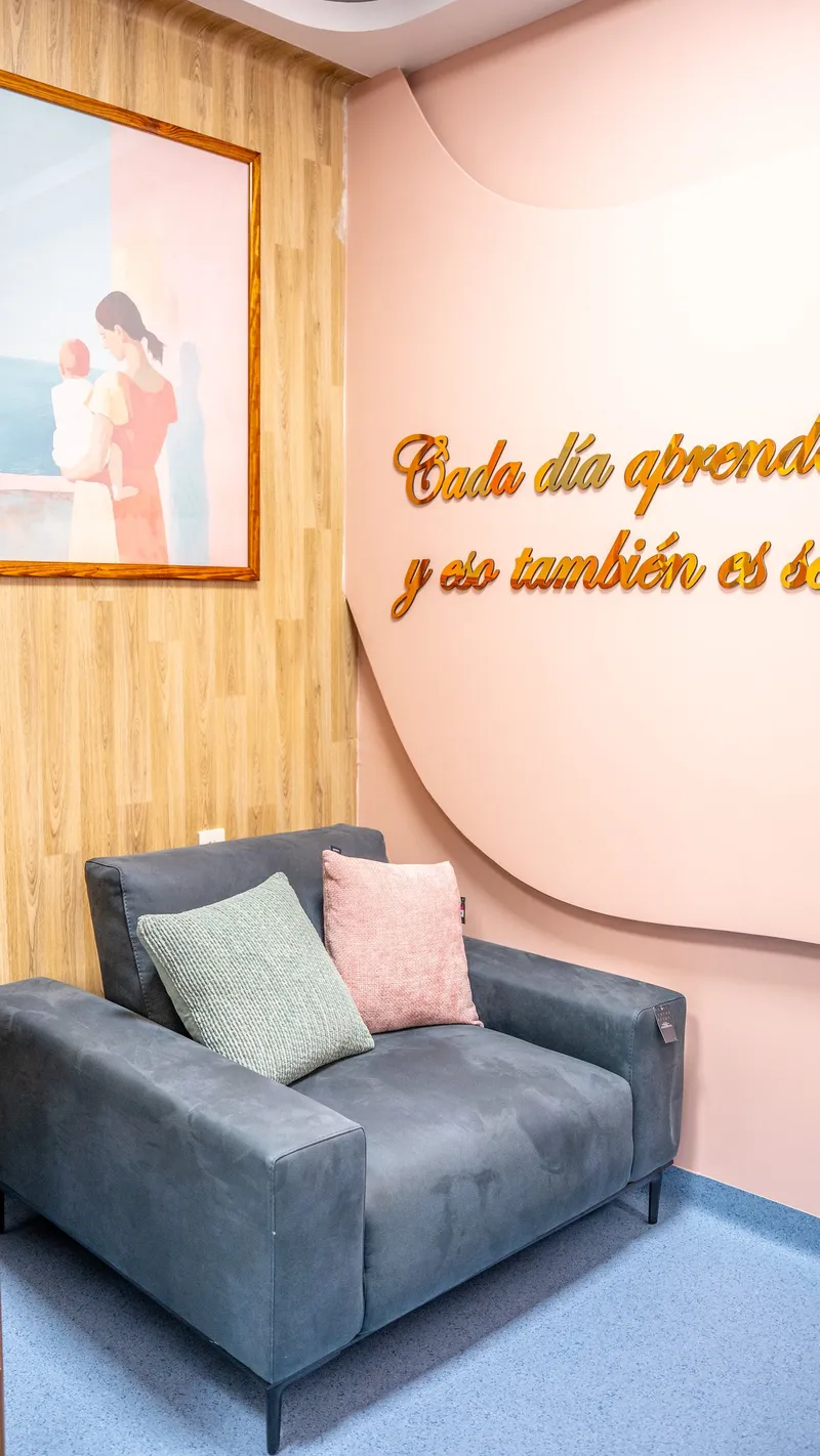 Sala con sillón y pared rosa dentro de la unidad